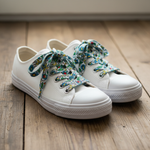 Folkstar Kashubian folk shoelaces laced up on white canvas sneakers on a wooden floor