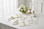 Elegant First Communion napkins on a white table with candles and white flowers