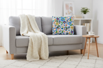Folkstar Kashubian folk pillow on a light grey linen sofa in a cozy Scandinavian living room