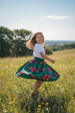 Young girl twirling in a vibrant green Polish folk rose skirt in a sunny garden