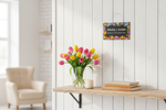 Folkstar Miłość i Zgoda metal sign hanging on a white wall with white rope and fresh tulips in a vase