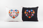 Both Monart Babcia embroidered folk cushions side by side — white and black versions
